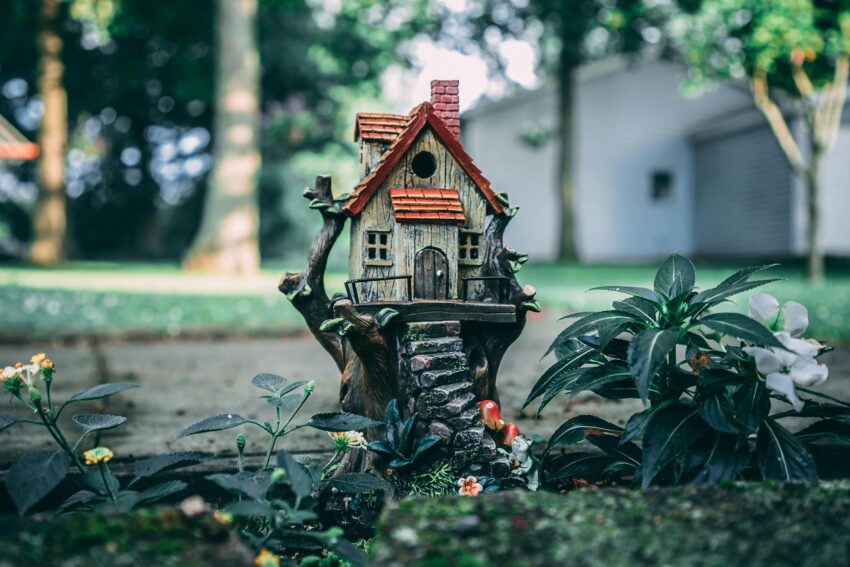 A whimsical miniature house set amidst a lush fairy garden, evoking a sense of enchantment and fantasy.